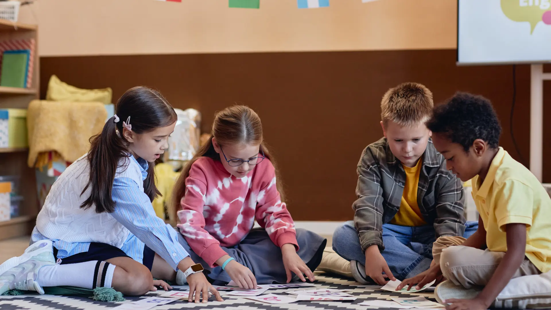  A group of children playing on a classroom rug, participating in emotional regulation activities for ages 6 to 10.
