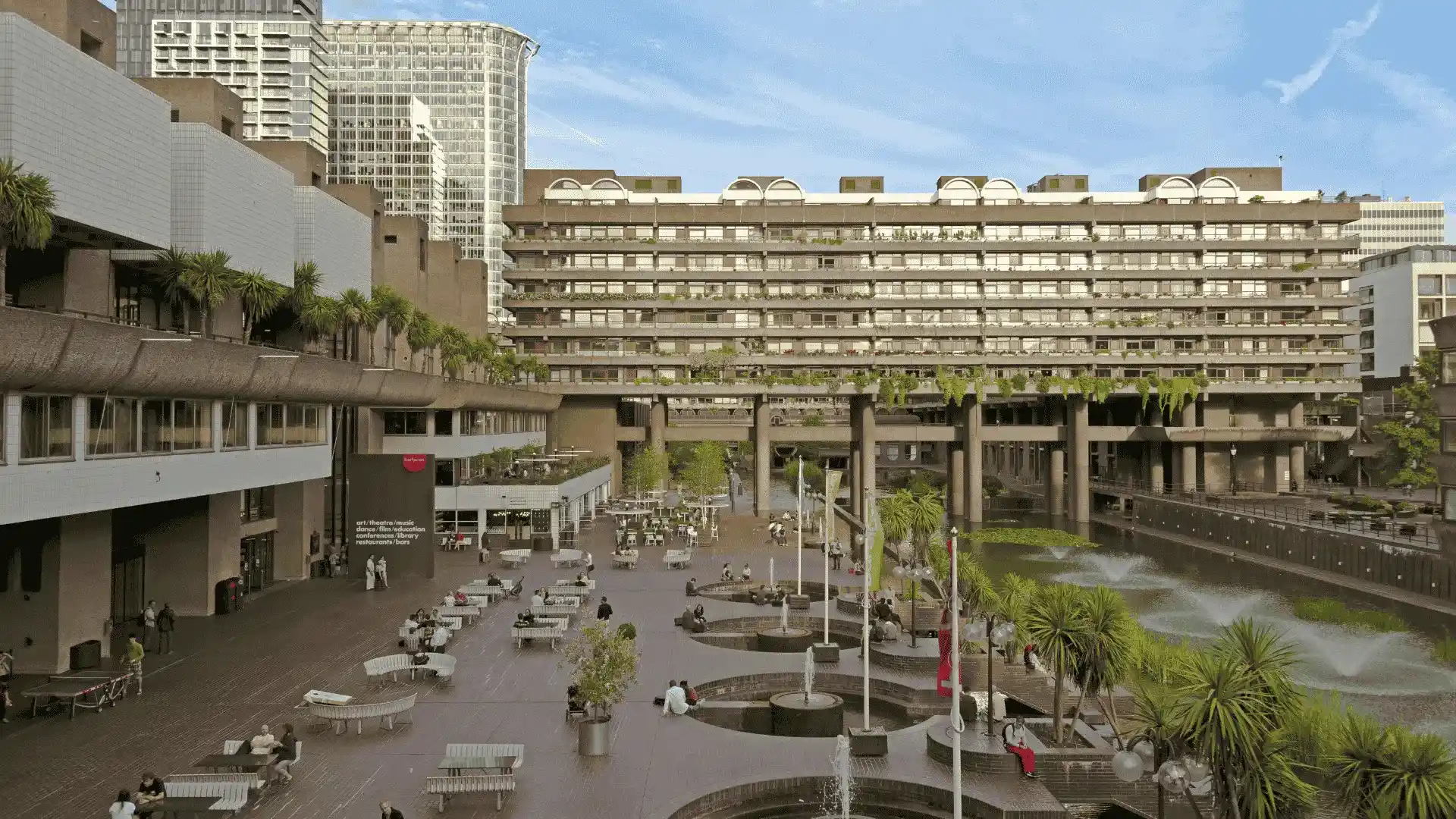 A large Brutalist building, the Barbican Centre, with a fountain in front, showcasing European architectural style.