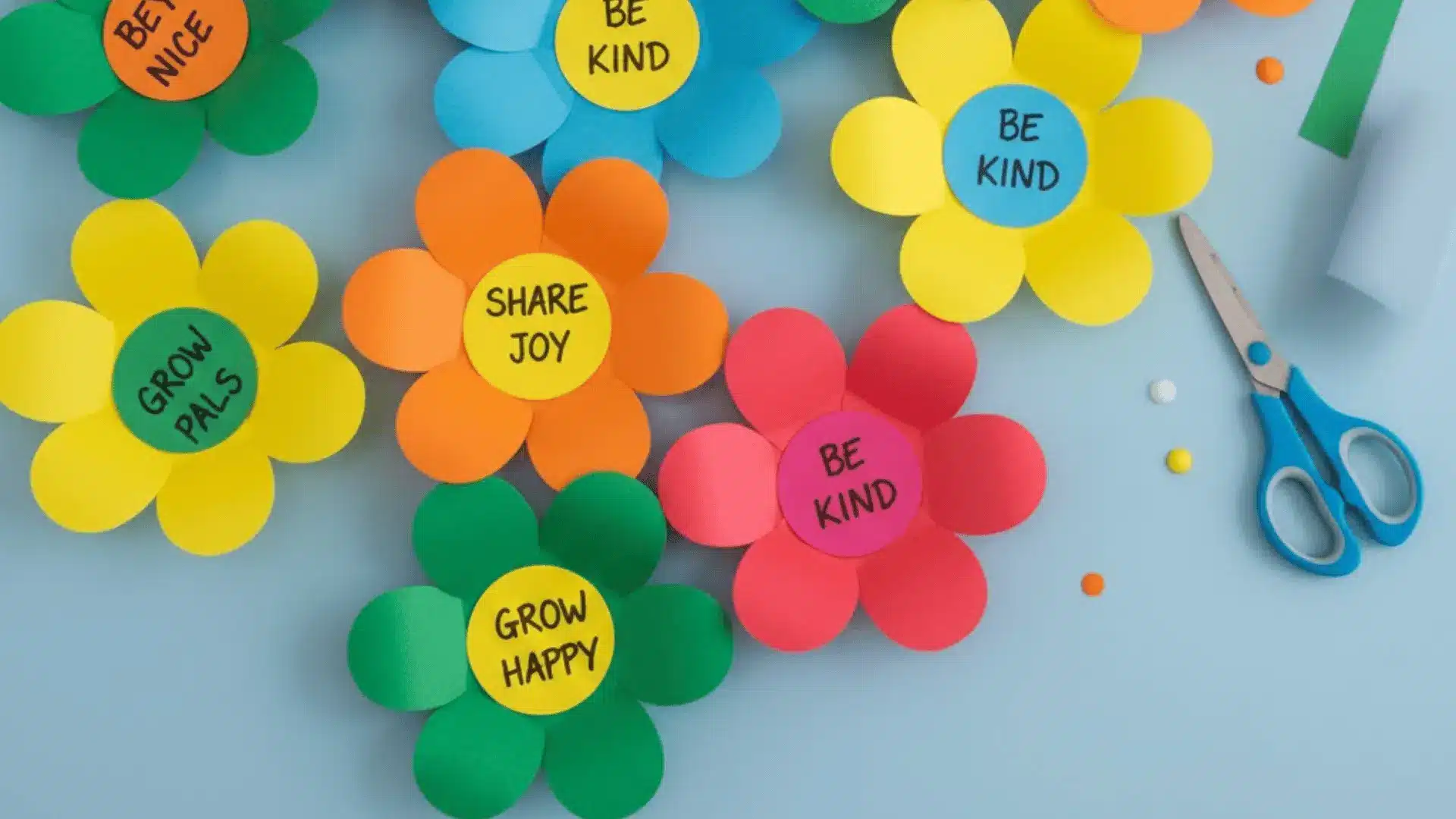 Colourful paper flower craft with petals showing simple kindness messages.