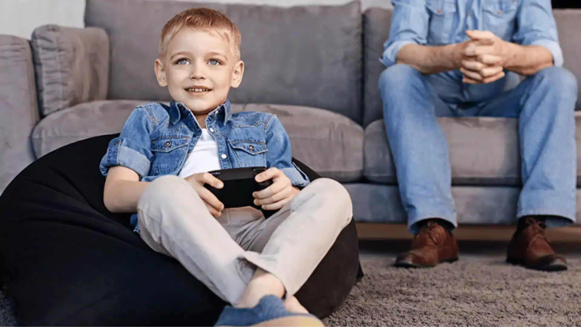 a father watching his son play a video game 