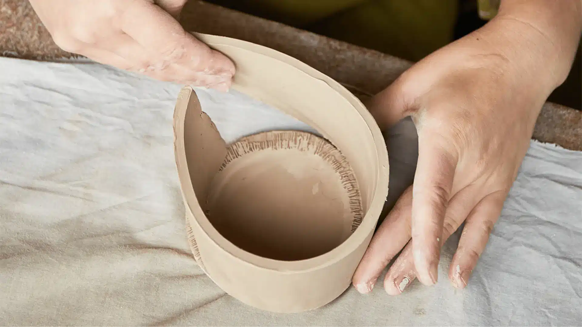  a person joining different slabs into one pottery 