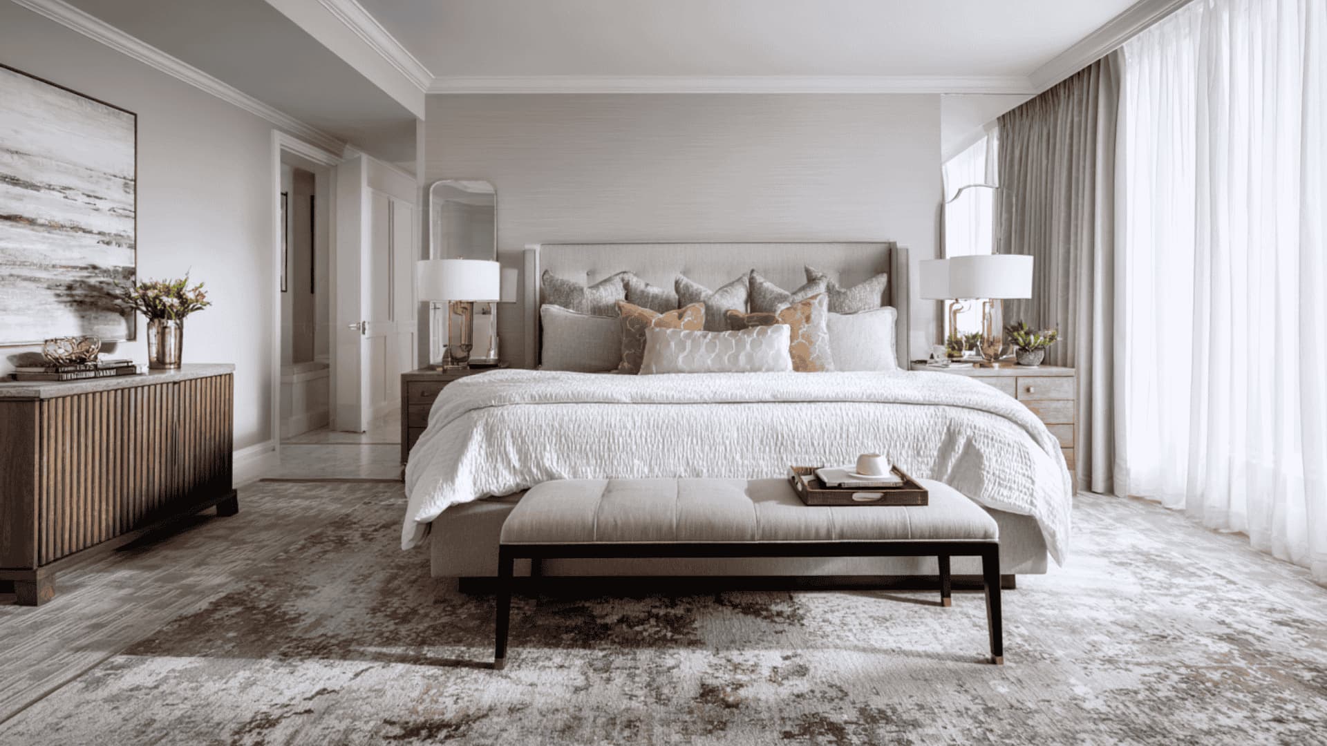  9'x12' rug fully under the king bed with nightstands and a bench for a balanced bedroom layout