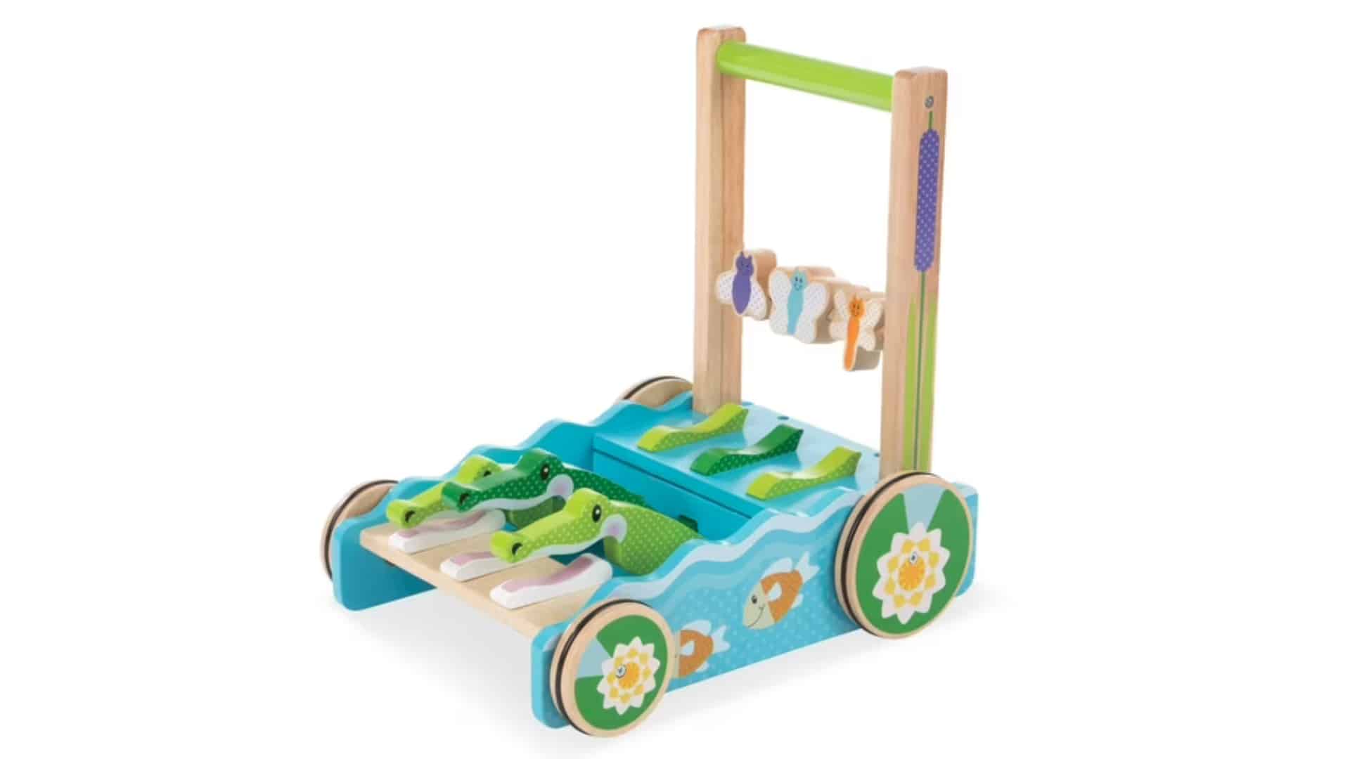 Bright wooden alligator push walker with clacking green pieces and sturdy handle, shown as a product photo on white