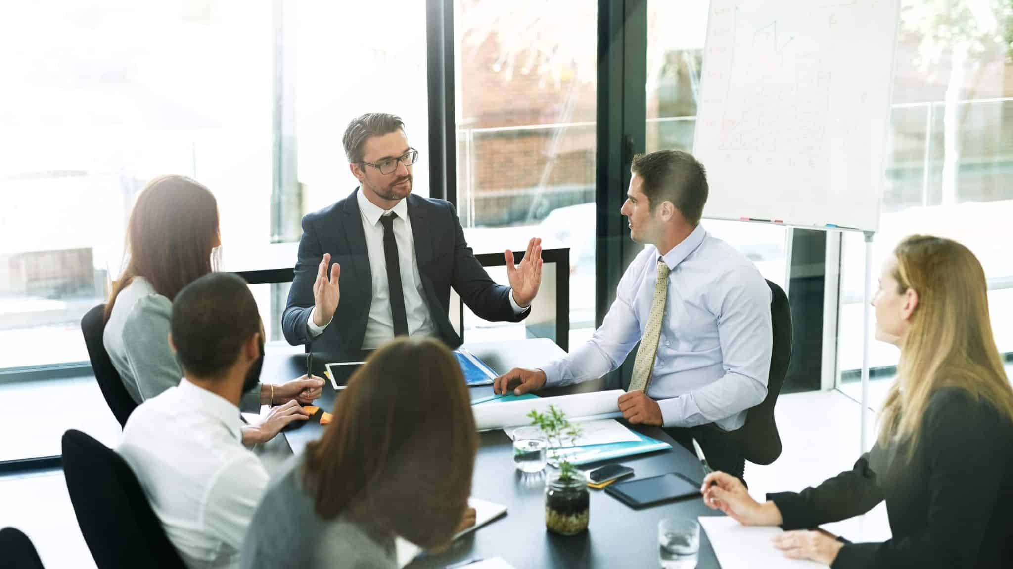 Senior leader sharing a personal story during a small team meeting in a modern office<